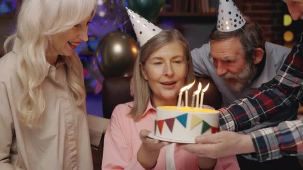 Oudere Dame Verjaardagsmuts Blaast Kaarsje Uit Verjaardagstaart Vieren Samen Met — Stockvideo