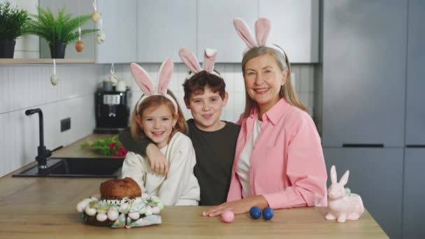 Großmutter Und Ihre Enkelkinder Verbringen Zeit Miteinander Tragen Hasenohren Sitzen — Stockvideo