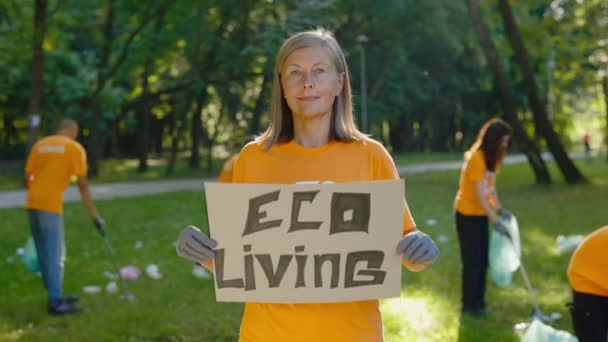 生态活海报 在肮脏的森林背景下 刻画成熟的活跃分子持有生态海报 公众示威 反对地球污染的抗议 — 图库视频影像