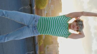 Dikey video. Beyaz tenli dansçı kameraya bakarken havalı hareketlerle çağdaş duygusal dans ederek gülümsedi. Dans eden adam. Erkek oyuncu eğitim becerileri