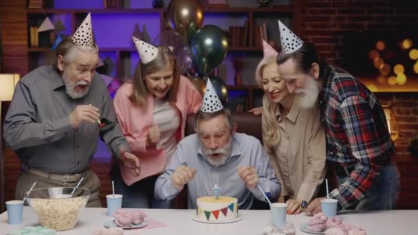 Hombre Anciano Divertido Sombrero Cumpleaños Soplando Vela Torta Cumpleaños Broma — Vídeos de Stock