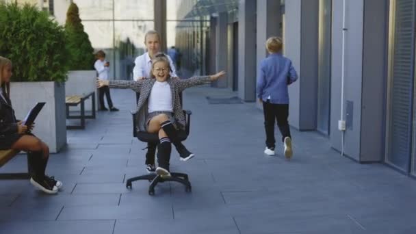 Små Företag Barn Kul Rida Kontorsstolar Utanför Nära Office Building — Stockvideo