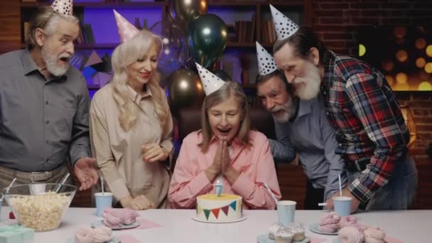Blonde Lächelnde Ältere Dame Mit Geburtstagsmütze Die Kerzen Auf Joke — Stockvideo