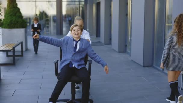 Kleine Zakelijke Kinderen Hebben Plezier Paardrijden Kantoorstoelen Buiten Buurt Van — Stockvideo
