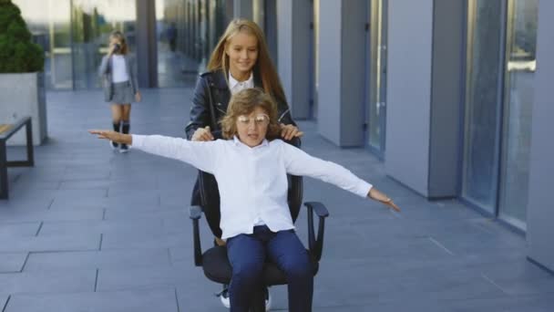 两个快乐的小商贩在下班后玩得开心 同事们在一起度过时光 坐在办公室的椅子上 学生在休息 一起玩吧玩的开心 — 图库视频影像