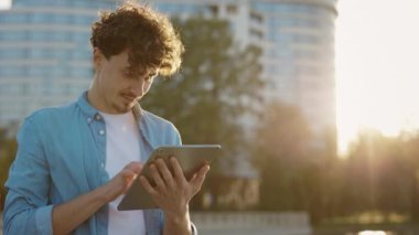 Kafkas Sakallı Adam Tablet Bilgisayar 'da sokak sörfü interneti üzerinde duruyor. Dışarıdaki genç adam tabletini kullanıyor, arkadaşlarıyla mesajlaşıyor. Erkek Kullanıcı Sohbeti Çevrimiçi Tarayıcı