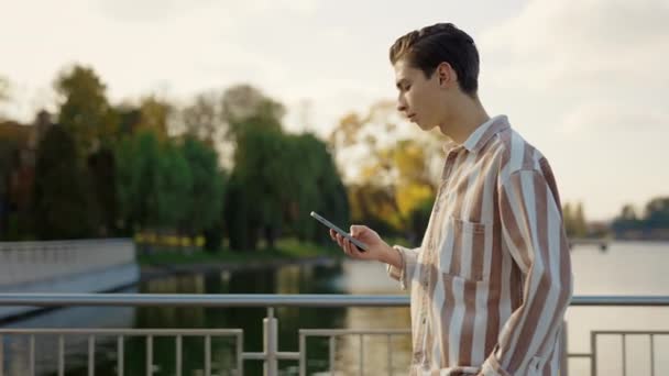 Boční Pohled Mladého Muže Kráčejícího Parku Pomocí Svého Chytrého Telefonu — Stock video