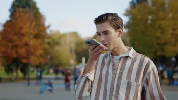 Mladý Běloch Neformálním Oblečení Chodí Telefonu Nahrává Hlasovou Zprávu Kterou — Stock video