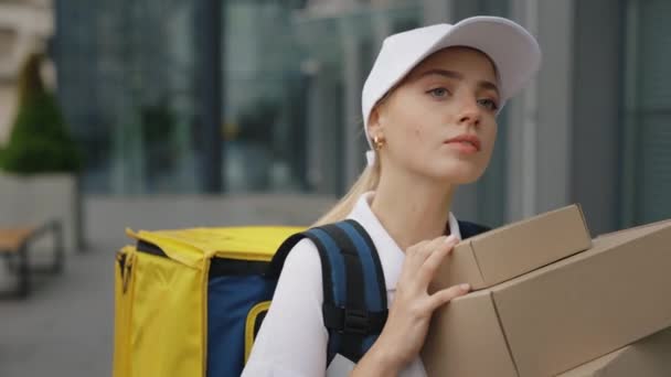 Mujer Caucásica Mensajera Uniforme Blanco Llevando Mochila Amarilla Sosteniendo Paquetes — Vídeos de Stock
