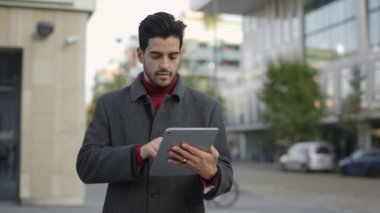 Şehirde Tablet Tarama Online kullanarak Yakışıklı Etnik Genç İşadamının portresi. Sokak Mesajları, Kaydırma Uygulamaları 'nda çalışan mutlu stil sahibi adam. Teknoloji ve İş Konsepti