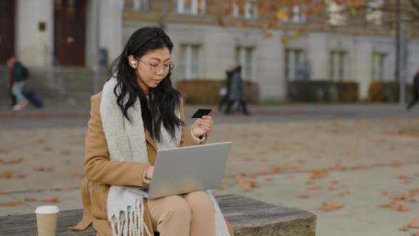 Gyönyörű Ázsiai Ügyfél Hitelkártyával Laptoppal Fülhallgatót Visel Instant Easy Mobile — Stock videók