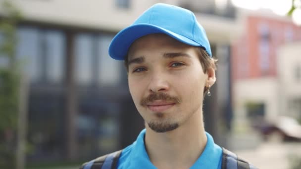Porträt Eines Lächelnden Kaukasischen Kuriers Blauer Uniform Mit Mütze Der — Stockvideo