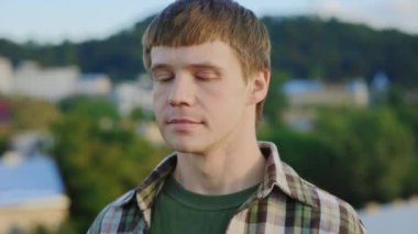 Yakışıklı, gülümseyen yetenekli dansçının yüz portresi çatıda kameraya poz veriyor. Çatıda poz veren erkek model. Eğlence. İnsanlar ve eylem konsepti