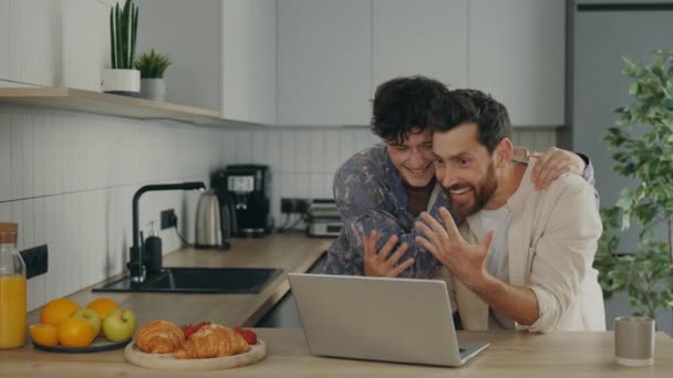 Lgbtのチューブ幸せを感じます ビデオ通話のためのラップトップを使用して陽気なカップルは 彼らの親戚にオンライン提案リングを表示します 彼らに良いニュースを伝えます 既婚男性とコミュニケーションと愛 Lgbtの概念 — ストック動画