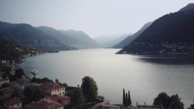 Drone shot of lake Como water in Alps of Italy. Aerial view of the lake and the mountains of the Como area. Sunrise