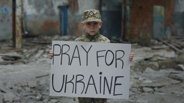 リトルソルジャー抗議戦争の肖像碑文マッサージテキストでバナーを保持ウクライナのために祈る 戦争に反対する子供 パトリオットだ ロシア戦争に反対する男性の子供 — ストック動画