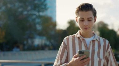 Sokakta yürüyen genç adam akıllı telefonunu kullanıyor, arkadaşlarıyla mesajlaşıyor. Gülümse İnternet Yüz Teknolojisi Mesajlaşma Çekici Cep Telefonu Yakışıklı Mesajı