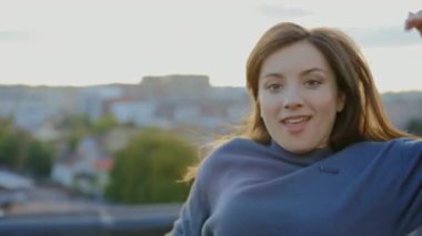 Güzel hip-hop kadının portresi duygusal olarak çatıda dans ediyor kameraya bakıyor ve dışarıda inanılmaz jestler ve hareketler yapıyor. Sokak dansı. İnsanlar ve eylem konsepti