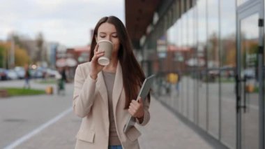 Kafkasyalı İş kadınının portresi. Yürüyen, kahve içen, dizüstü bilgisayar tutan. Kahve molası sırasında ofis binasının yanındaki çekici patroniçe. Laptop taşıyorum. Mutlu Bayan O İşçi Dışarıda