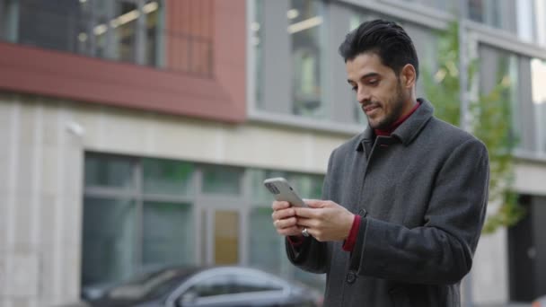 Πολυφυλετικός Όμορφος Γενειοφόρος Άντρας Στέκεται Έξω Κρατώντας Smartphone Και Swiping — Αρχείο Βίντεο