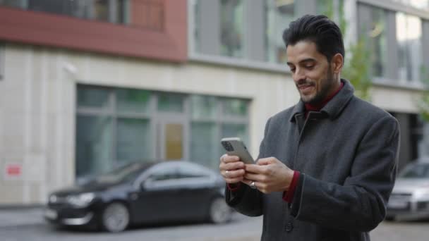Gülümseyen Çoklu Etnik Şadamı Müşterilerle Mesajlaşıyor Akıllı Telefonu Dışarıda Kullanıyor — Stok video