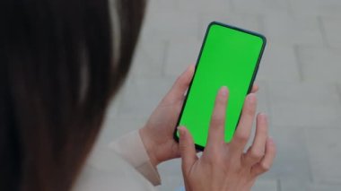 Smartphone in Hand 'de Chroma Key Mock-Up. Kadın Cep Telefonu Tutuyor ve Dışarıdaki Fotoğrafları ve Resimleri Dinliyor. Chroma Key Akıllı Telefon Teknolojisi Cep Telefonu Sokak Dokunuşu Mesajı Görüntüleme Elleri