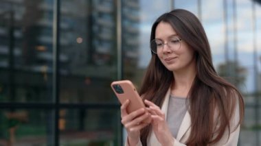 Şaşırdım, Kafkasyalı Güzel İş Kadını Dışarıda Büyük Şehir Caddesinde Güzel Haberler Okuyor. Kazan. Telefonla Zaferi Kutlayan Kadın