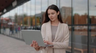 Şirin İş Kadını Ayakta Duruyor, Ofis Binası 'na yakın bir yerde çalışıyor. Bilgisayarı kameraya bakmak için kullanıyor. Yönetici bilgisayarı tutuyor. Mutlu Bayan O İşçi Dışarıda