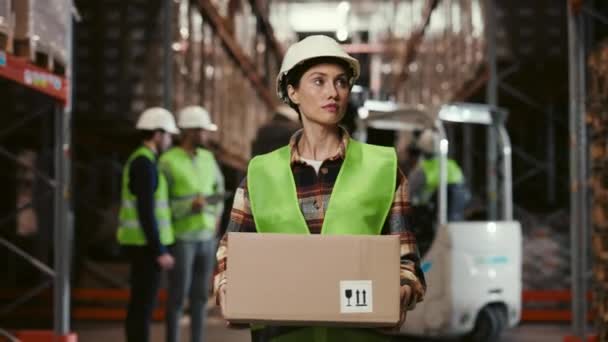倉庫内の魅力的な女性労働者は ストレージにパッケージを運ぶ 物流センターで段ボールウォーキングを持つ女性マネージャー 物流事業配送 配送コンセプト — ストック動画