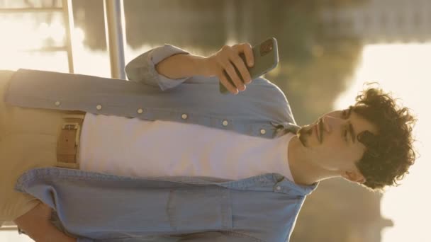 Κάθετη Βίντεο Σγουρά Μαλλιά Άνθρωπος Στέκεται Στο Δρόμο Χρησιμοποιώντας Smartphone — Αρχείο Βίντεο