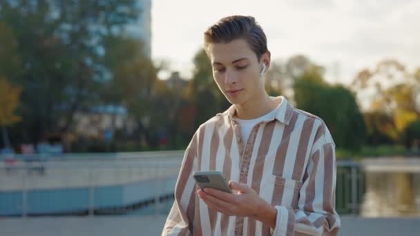 Biały Młodzieniec Słuchawkach Świętuje Osiągnięcie Patrząc Smartfon Zwycięstwo Mężczyzny Telefonem — Wideo stockowe