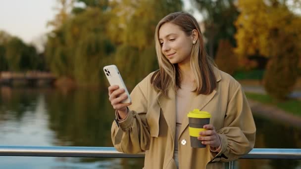 Όμορφη Γυναίκα Influencer Στέκεται Στο Πάρκο Χρησιμοποιώντας Smartphone Της Για — Αρχείο Βίντεο