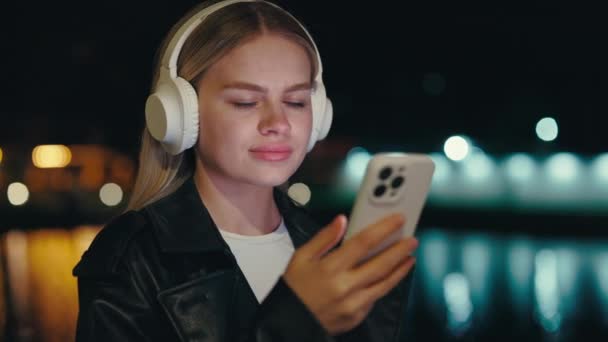 Mulher Elegante Desfrutando Seu Telefone Com Fones Ouvido Brancos Enquanto — Vídeo de Stock