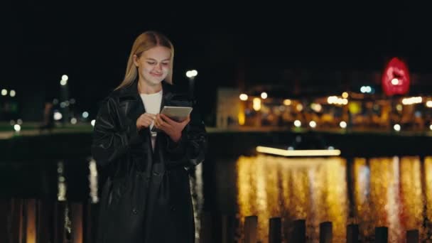 Όμορφη Κοπέλα Χαμογελώντας Στέκεται Κοντά Στη Λίμνη Της Πόλης Χρησιμοποιώντας — Αρχείο Βίντεο