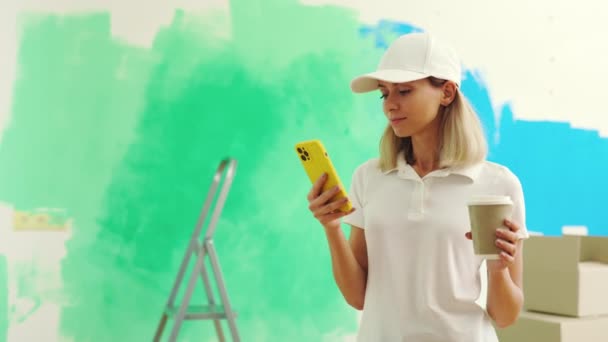 Female Worker Standing Texting Clients Painting Wall Drinking Coffee Woman — Stock Video