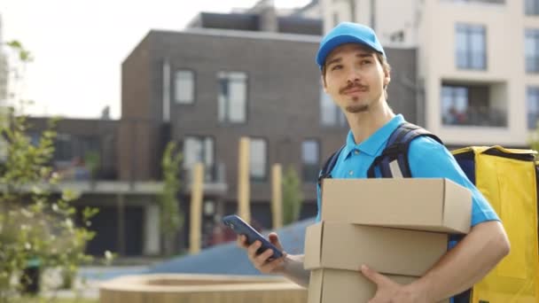 Courier Going Building Segurando Caixas Papel Telefone Celular Mão Homem — Vídeo de Stock