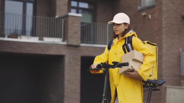 Attractive Caucasian Lady Courier Walking Bike Building Holding Paper Boxes — Stock Video