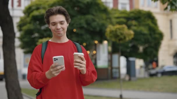 英俊的白人男子与棕色头发举行咖啡 使用电话 走在市中心的大街上 带手机到户外旅游的游客 慢动作人与技术概念 — 图库视频影像