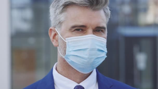 Twarz Dojrzałego Białego Przystojnego Menedżera Masce Medycznej Podczas Pandemii Patrząc — Wideo stockowe