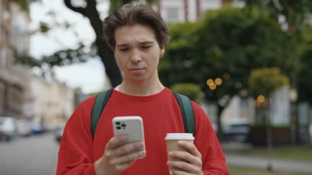 Возбужденный Красивый Молодой Человек Держит Мобильный Ходить Открытом Воздухе Читать — стоковое видео