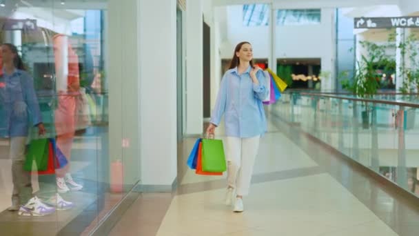쇼핑몰에 들어가는 쇼핑객 자랑스럽게 봉지에 그녀의 구매를 성공적인 스프링 그녀의 — 비디오