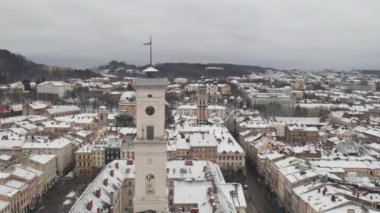 Ukrayna, Lviv şehrinde insansız hava aracı uçuşu. Büyüleyici, karla kaplı belediye binası ve meydanı. Kışın Eski Atmosferik Şehir Merkezi 'nin Hava Görüntüsü. Turistik bir yer. Seyahat ediyorum. Tarihi Konumlar Konsepti