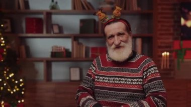 Yeni yıl dekore edilmiş huzurevinde oturan tekerlekli sandalyedeki yaşlı adamın portresi. Kıdemli Geyik Hoop Giyen Erkek, Kış Tatili 'nin tadını çıkarıyor. Yeni Yıl veya Noel ve Engelliler Konsepti