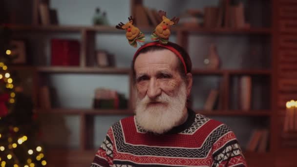 Positive Elderly Man Wearing Deer Antler Hoop Sitting Living Room — Stock Video