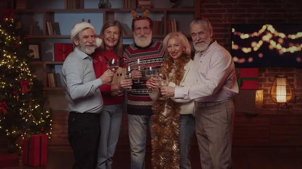 Yeni yıl partisi. Olgun Moda Dostları 'nın Portresi Dekoratif Bir Oturma Odasında Birlikte Duruyor, Mutlu Hissediyor, Dekorasyon Evindeki Kameraya Bakıyor