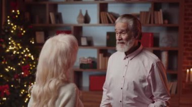 Huzurevinde kıdemli çift Noel hediyelerini kucaklıyor ve değiş tokuş ediyor, Yürek ısıtan Dostluk ve Kutlama Anı yaratıyor. Neşeli Atmosfer ve Neşeli Yaşlılar Dostluğu