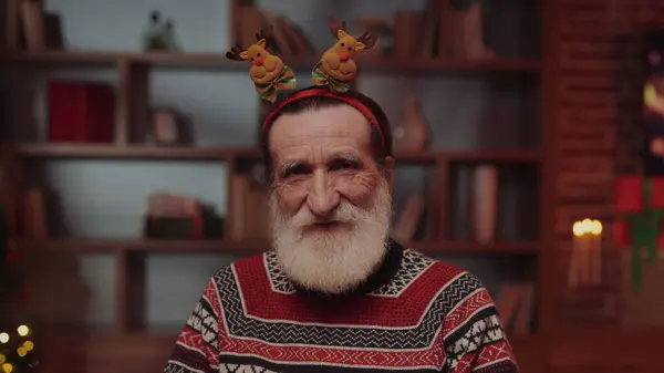 Yeni yıl arifesinde Geyik Antler Hoop 'u giyen yaşlı adam oturma odasında oturuyor. Yeni yıl tatilleri. Noel Arifesi ya da Yeni Yıl Tatil Kutlaması Kavramı