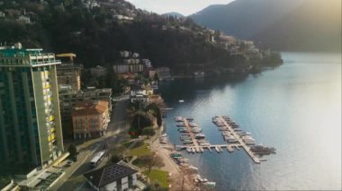 Göl kıyısındaki şehir manzarası, Uzun Binalar ve Yat Kulübü. Göl kıyısında bir Lugano kasabası, Dağların Arkasına Karşı. Seyahat ve Turizm Konsepti