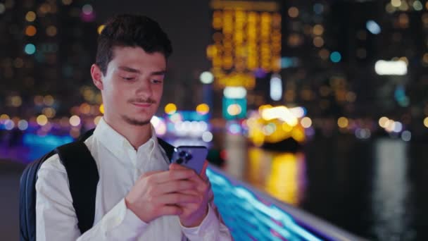 积极的家伙游客在手机浏览 站在外面的夜晚 英俊的男性旅行者在智能手机上打字和使用 在网上搜索 城市环境 技术概念 — 图库视频影像