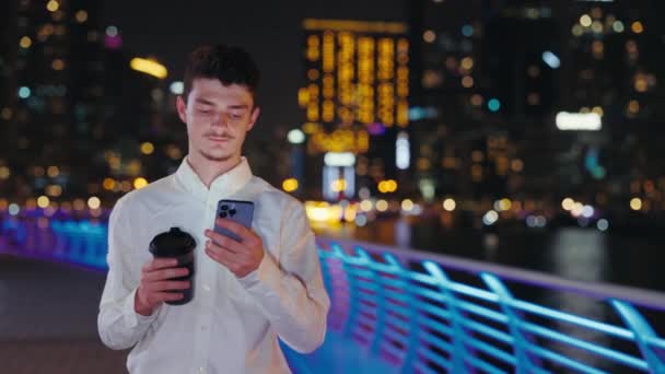 可爱的年轻人与朋友聊天 独自在夜城散步 用他的手机 浏览互联网 技术概念 — 图库视频影像